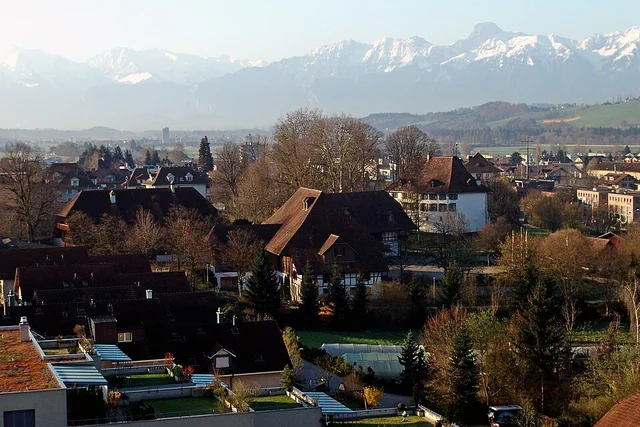 Tenuta del castello di Münsingen con edifici storici davanti alle montagne – rappresentazione sfocata